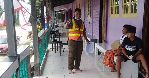 Environmental field team speaking with community members at a village home